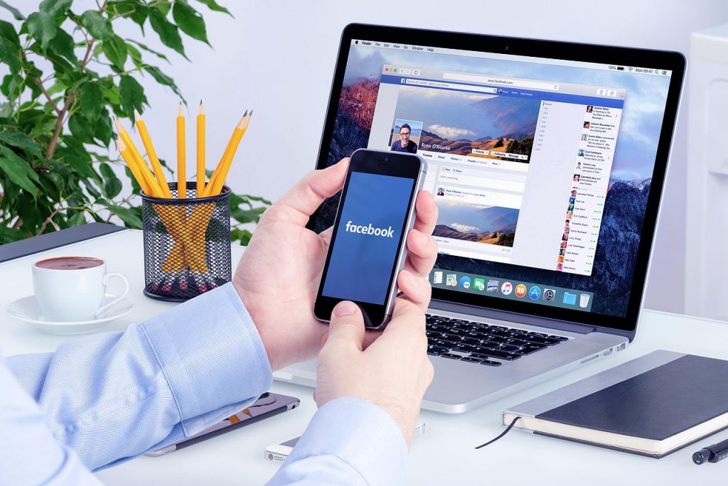 Image of person on their phone logging into the Facebook app